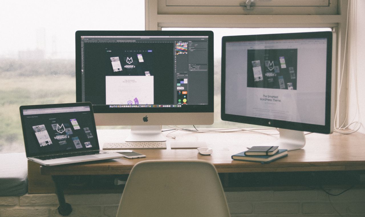 services-img Stylish and efficient workspace with multiple monitors, laptop, and smartphone, showcasing a web design project.