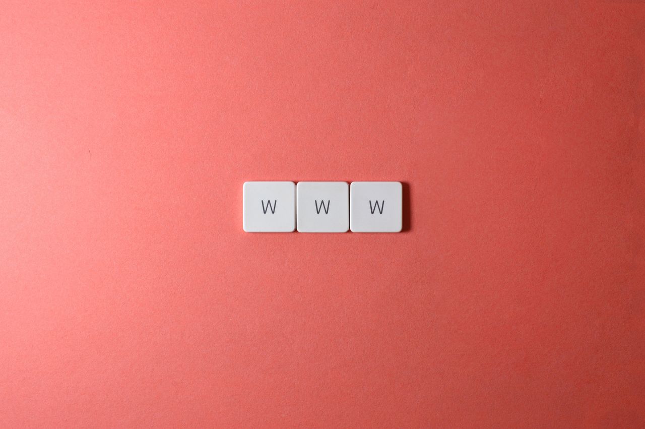 hero-img-02 Close-up of WWW keyboard keys on a vibrant red surface, ideal for digital concepts.
